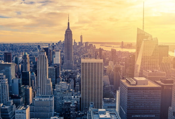 Sunset view of the New York City skyline, highlighting the global reach of StoneX's innovative service offerings in trading, execution, and payments