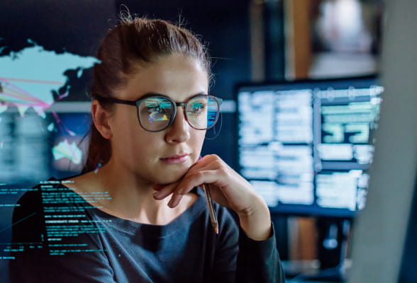 Woman intensely working on a computer, reflecting StoneX's global FX market services for corporate clients