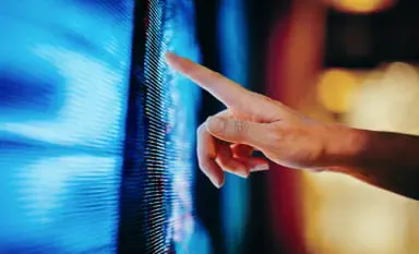 A person's finger touches a computer screen, exploring StoneX's extensive fixed-income market coverage