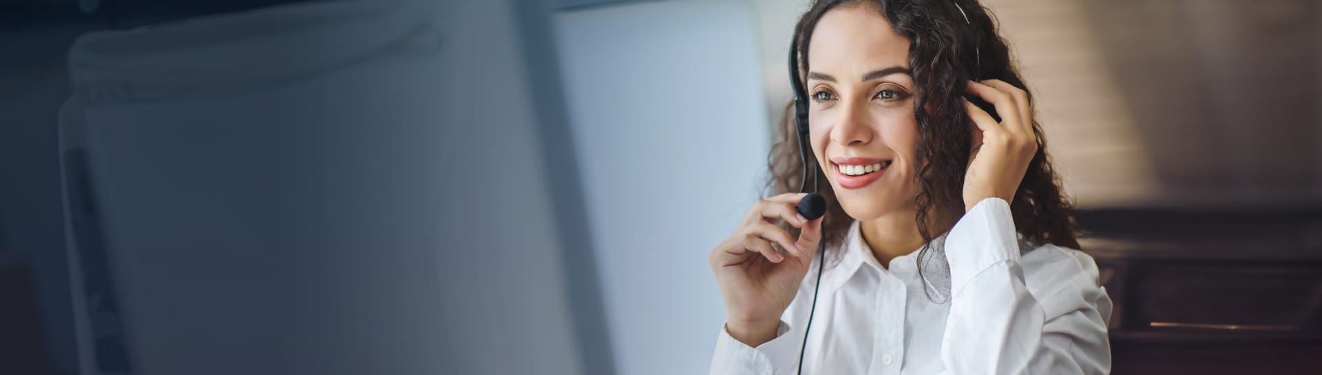 Support agent with a headset, representing StoneX Payments' global customer support.