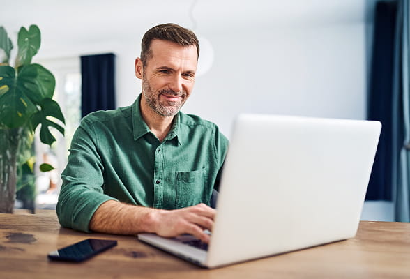 Investor reviewing digital asset market intelligence on a laptop, representing StoneX Digital’s institutional research insights.