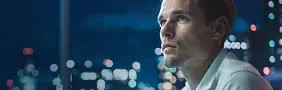 Financial professional looking at city skyline, representing StoneX Global Prime Services' comprehensive prime brokerage solutions.