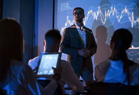 Presenter discussing market data with an audience, representing liquidity expertise and efficient onboarding for family offices.