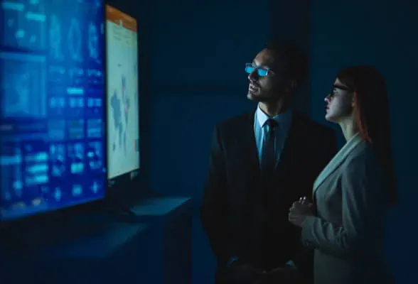 Two professionals analyzing data on screens, representing StoneX Pro's liquidity expertise and efficient onboarding for hedge funds.