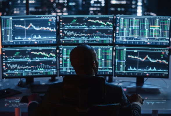 Professional monitoring multiple trading screens, illustrating scalable FX technology solutions and global market access for money service businesses.
