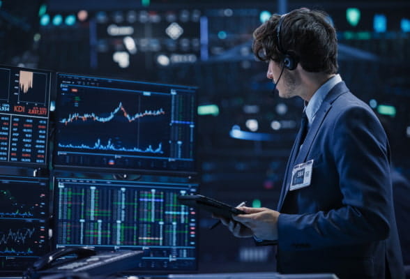 Trader monitoring multiple screens, representing StoneX Pro's institutional-grade FX technology and platform solutions for proprietary traders.