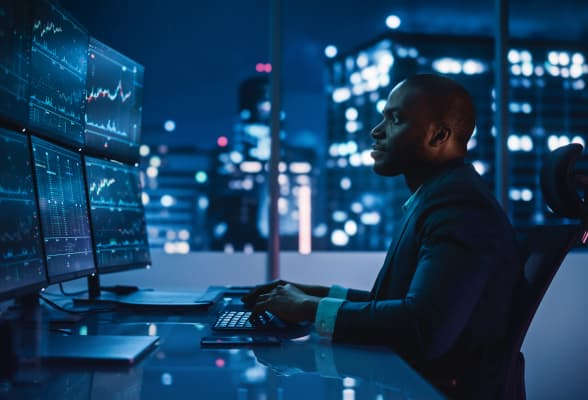 Trader working on multiple screens, representing institutional liquidity and advanced FX solutions for retail brokers.