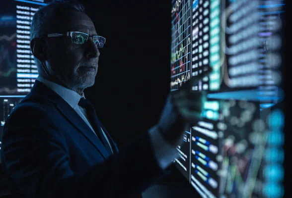 Trader interacting with data on multiple screens, illustrating scalable technology solutions and seamless integration for hedge funds.