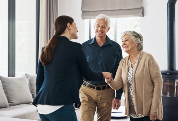 Financial advisor greeting a couple, representing StoneX Wealth Management's personalized investment planning and private client services
