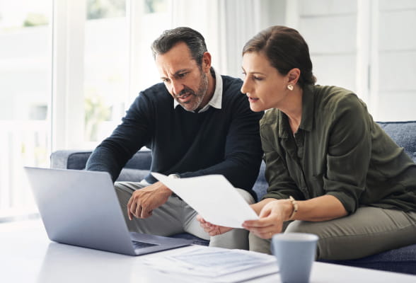 Two people reviewing financial documents, highlighting StoneX Wealth Management's advisory solutions, products, and support services for advisors