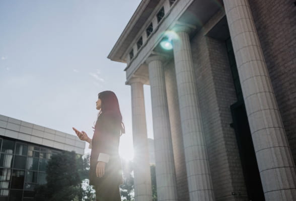 Professional standing outside a building, highlighting StoneX Wealth Management's comprehensive investment solutions for wealth managers