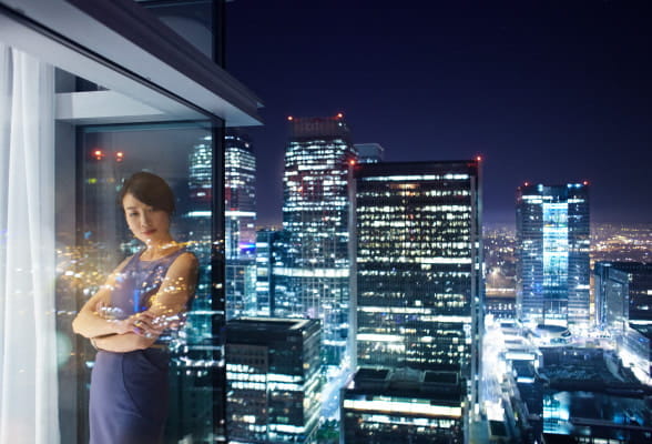 Professional standing by a window overlooking a city skyline, illustrating StoneX Wealth Management's tailored affiliation options