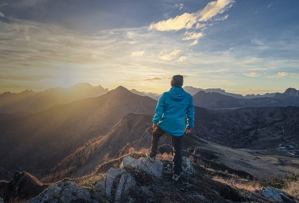 Indivíduo observando uma paisagem montanhosa, simbolizando independência financeira e gestão patrimonial estratégica com a StoneX.