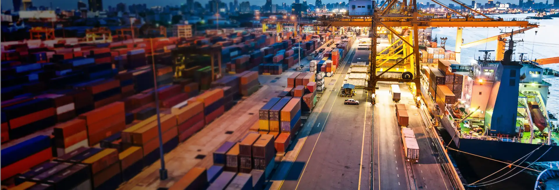 Um navio atracado em um porto cercado por contêineres de carga prontos para o transporte de commodities físicas